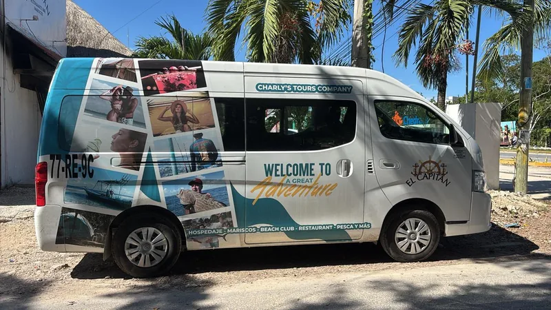 Camioneta de Charly’s Tours Company, rotulada con fotos de cenotes, tortugas y pesca, y con el logotipo de El Capitán en la puerta